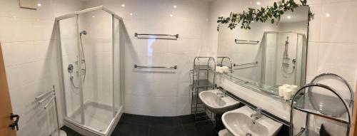 a bathroom with two sinks and a shower and two mirrors at Ferienwohnung Schranz in Innsbruck