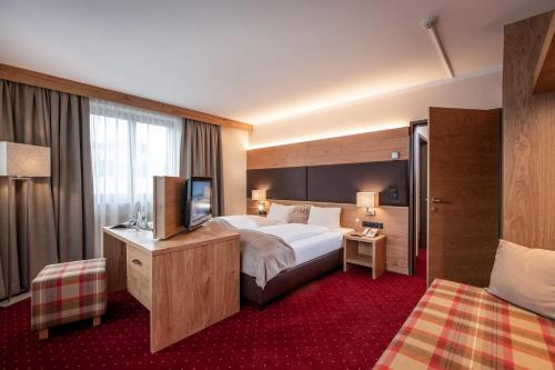 a hotel room with a bed and a television at Hotel Andreas Hofer in Kufstein