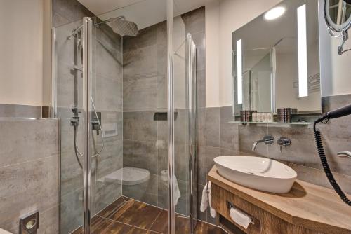 a bathroom with a glass shower and a sink at SPREE Hotel in der Altstadt in Lübbenau