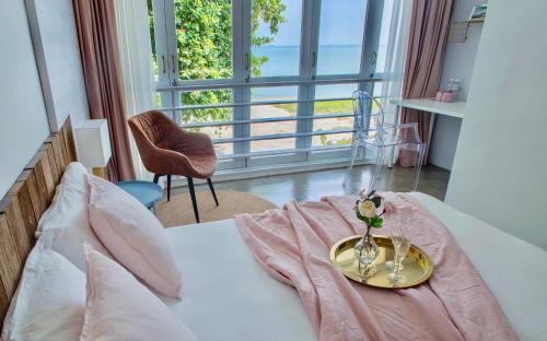a bed with a plate with a vase of flowers on it at Smell rose beach garden花语海沙滩花园 in Batu Ferringhi