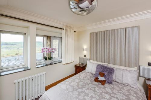 a teddy bear sitting on a bed in a bedroom at The Saddleworth Hotel in Diggle