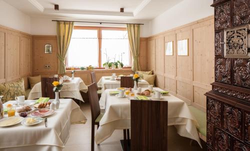 a restaurant with tables with white tablecloths at Garni Appartment Wagnerhof in Rablà