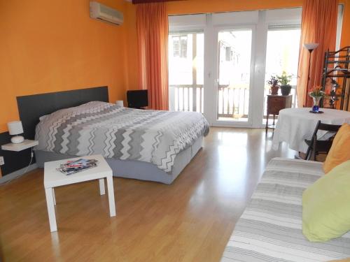 1 dormitorio con cama, mesa y sofá en Nid de cigognes, en Rosheim