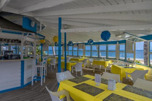Costarena Beach Hotel في لاس تاريناس: مطعم بطاولات صفراء وكراسي بيضاء
