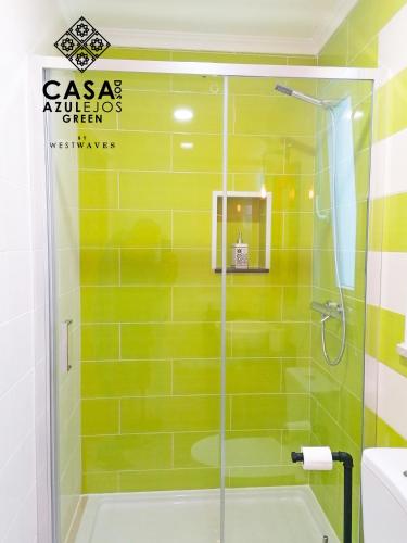 a bathroom with a shower with green tiles at Casa do AZULejo - Green in Peniche