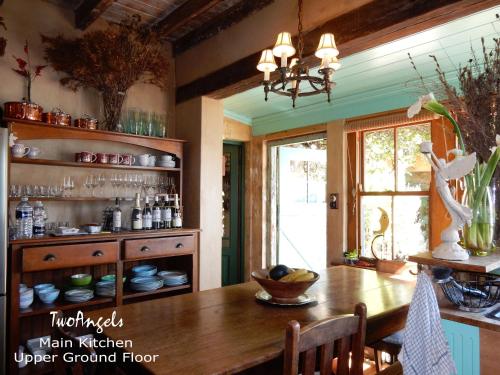 a kitchen with a wooden table and a window at TwoAngels in Knysna
