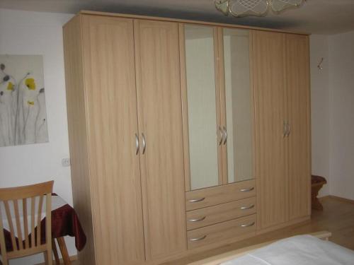a large wooden cabinet with glass doors in a bedroom at Ferienwohnungen Pötscher Maria in Matrei in Osttirol