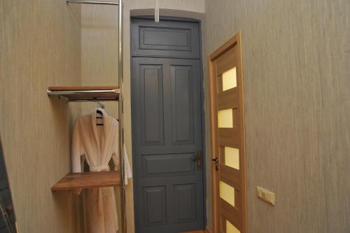 a bathroom with a blue door and a robe at Brickwall Tbilisi-Tbilisi vibe in Tbilisi City