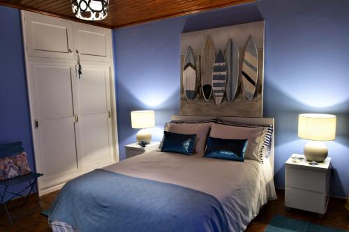 a bedroom with a bed with two lamps and surfboards on the wall at Salty Stories in Ponta Delgada