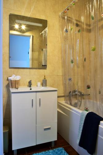 a bathroom with a sink and a shower with a mirror at Salty Stories in Ponta Delgada