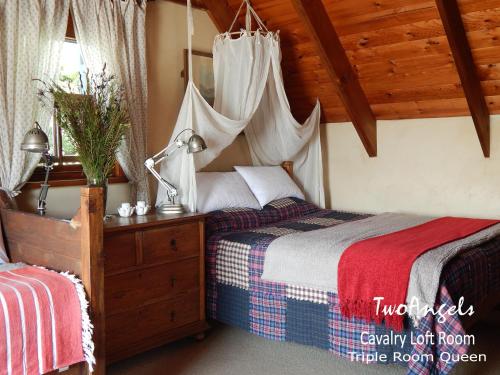 a bedroom with two beds and a canopy top room at TwoAngels in Knysna
