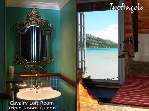 a bathroom with a sink and a window with a view of the ocean at TwoAngels in Knysna