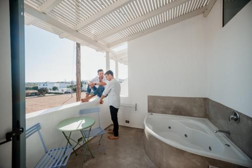 two people standing in a bathroom with a tub at The Saint Vlassis in Naxos Chora