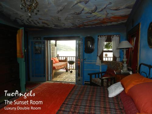 a bedroom with a bed and a living room at TwoAngels in Knysna
