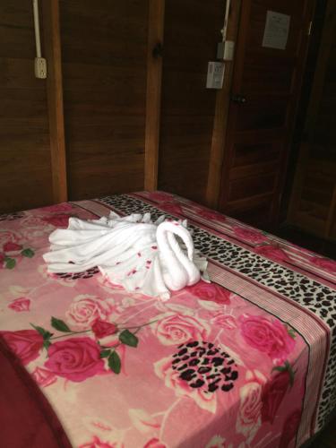 a bed with a towel on it with roses on it at Matus Guest House in San Ignacio