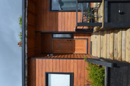 a wooden house with a deck and a staircase at Valdivia, Cabañas camino a Niebla in Valdivia