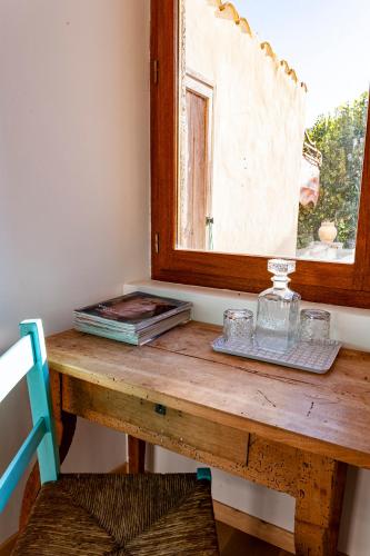 a wooden table in a room with a window at La Vieille Auberge in Vesc