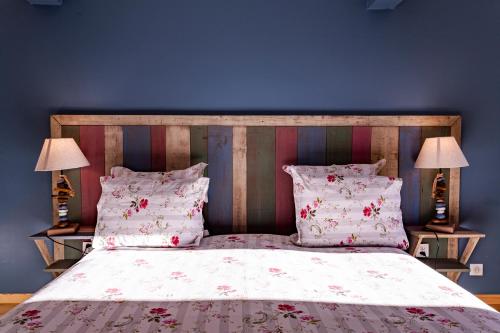 a bedroom with a large bed with two lamps at La Vieille Auberge in Vesc