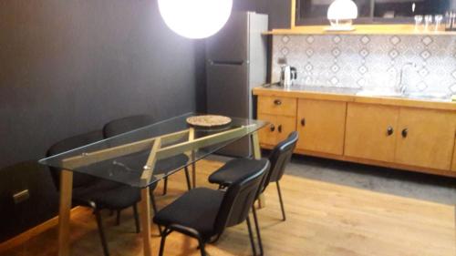 a kitchen with a glass table and black chairs at Valdivia, Cabañas camino a Niebla in Valdivia