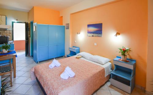 a bedroom with a bed and a blue cabinet at Panos Apartments in Benitses