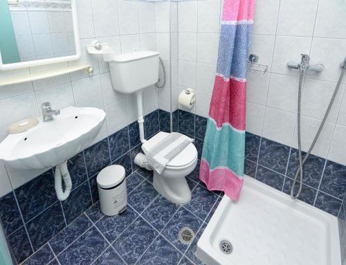e bagno con servizi igienici, lavandino e vasca. di Panos Apartments a Benitses