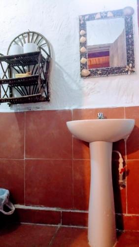 a bathroom with a white sink and a mirror at Guacamayo Rooms & Bungalows in Máncora