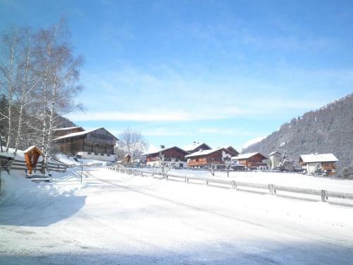 a snow covered village with houses and a fence at Ferienwohnungen Pötscher Maria in Matrei in Osttirol