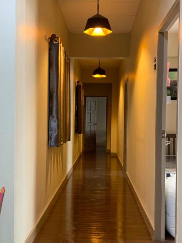 an empty hallway with a long floor and a light fixture at Achcha hotel - itsaraphap MRT station - Wat Arun in Bangkok