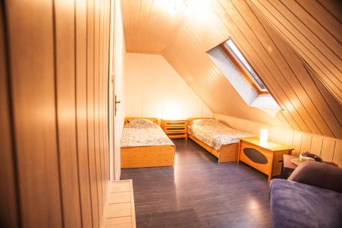 a attic room with two beds and a window at Domek Epona in Szklarska Poręba