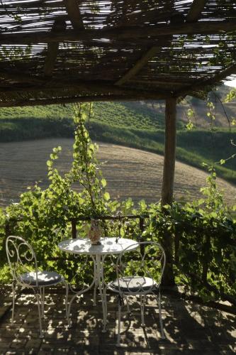 a table and chairs sitting under a pergola at Egesta, villa with private pool in Calatafimi