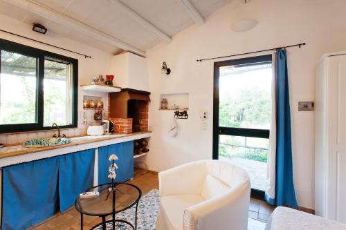 a living room with a white chair and a counter at Egesta, villa with private pool in Calatafimi