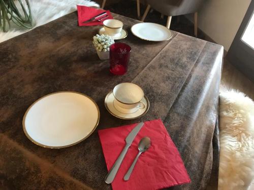 ティーニュにあるLe Terril Blancの木製テーブル(白皿、赤ナプキン付)