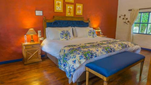 a bedroom with a bed with a blue and white comforter at Hostería Hacienda Pinsaqui in Otavalo