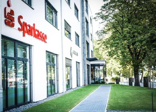 a facade of a building with a grass yard at Prime Park Apartment Aschaffenburg mit Terrasse in Aschaffenburg