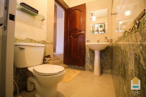 a bathroom with a toilet and a sink at Airport Green Olive Villa in Katunayaka