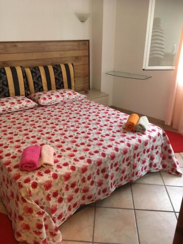 1 dormitorio con 1 cama con edredón rojo y blanco en A’ ca’ de Giuli’, en Badalucco