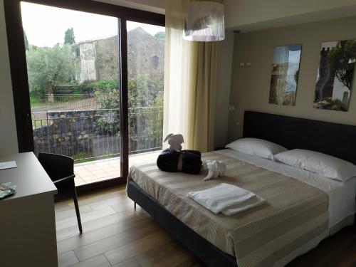 a teddy bear sitting on a bed in a bedroom at SOTTO L'EREMO in Aci Catena