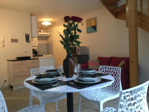 une table de salle à manger avec un vase de fleurs dessus dans l'établissement Le tapis vert, à Cahors