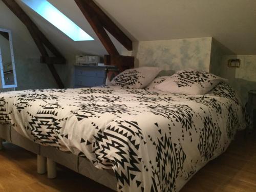 sypialnia z łóżkiem z czarno-białą kołdrą w obiekcie Le tapis vert w mieście Cahors