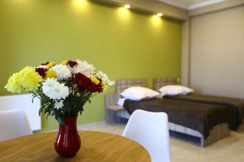 wazon kwiatów siedzący na stole w sypialni w obiekcie Brick House II w mieście Tbilisi City
