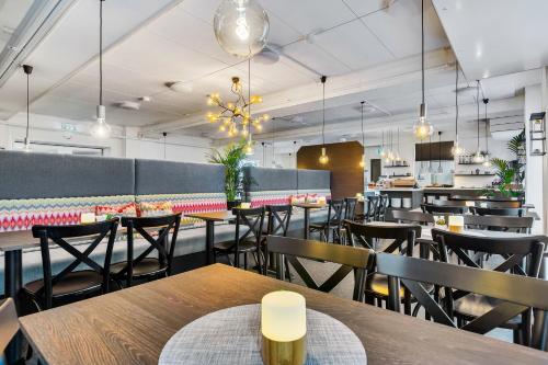 a dining room with tables and chairs in a restaurant at Aiden by Best Western Harstad Narvik Airport in Harstad