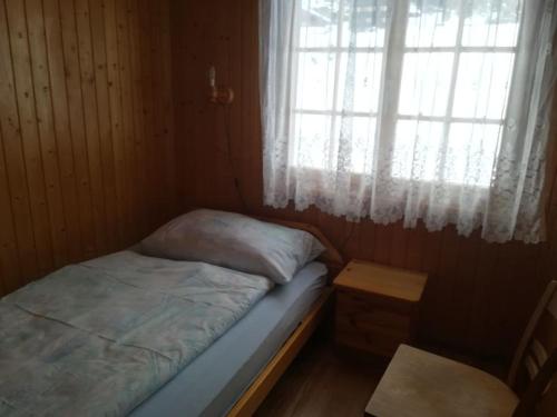 een kleine slaapkamer met een bed en een raam bij Irene in Bitsch
