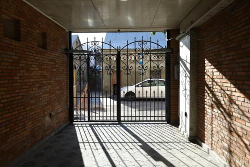 een open poort met een witte auto op een parkeerplaats bij Brick House in Tbilisi City