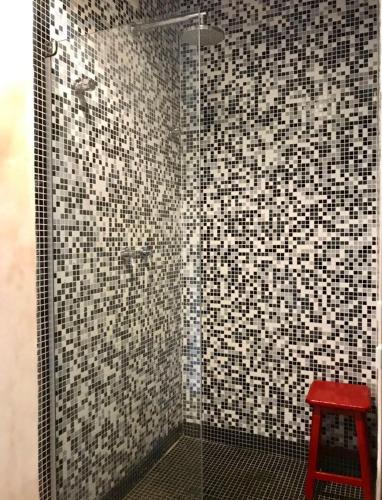 a shower with a red stool in a bathroom at House da Lui in Ubatuba