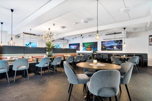 a restaurant with tables and chairs in a room at Aiden by Best Western Harstad Narvik Airport in Harstad