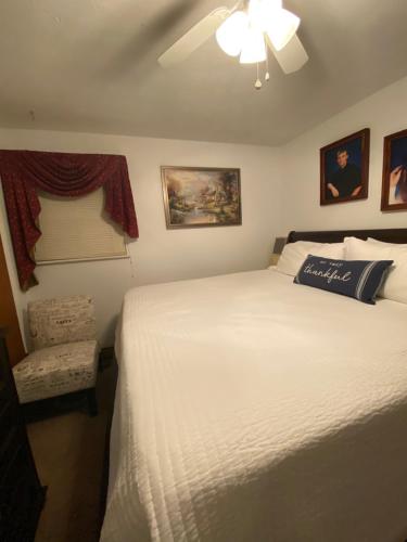 sypialnia z białym łóżkiem i wentylatorem sufitowym w obiekcie Our Home, Your Home w mieście Black Mountain