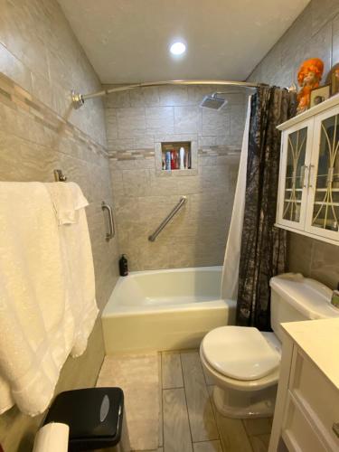 a bathroom with a tub and a toilet and a sink at Our Home, Your Home in Black Mountain