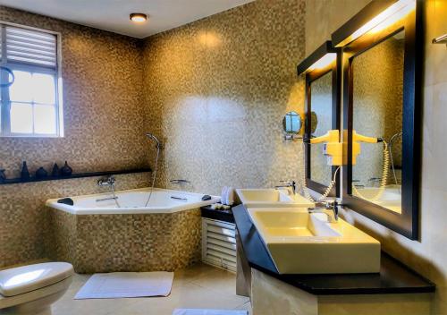 a bathroom with two sinks and a tub and a toilet at The Blackpool Resort & Spa in Nuwara Eliya