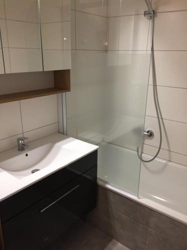 a white bathroom with a sink and a shower at TraunseeBlick in Altmünster