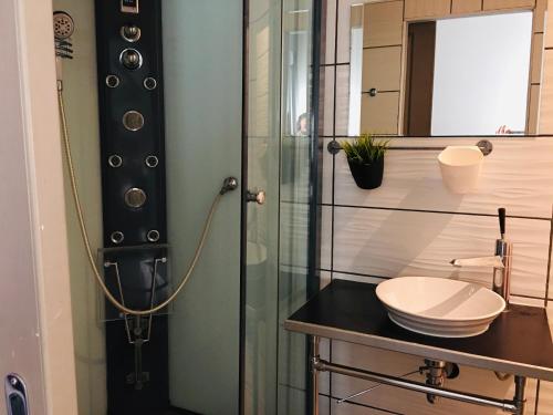 a bathroom with a glass shower and a sink at L'Avenue in Agde